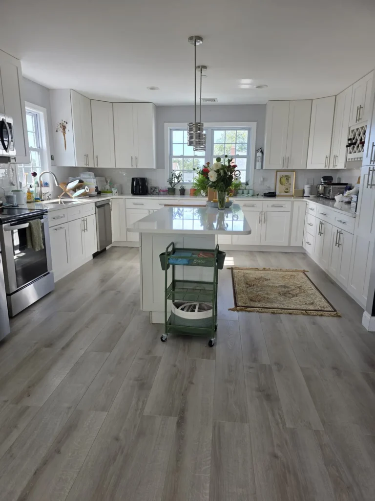House cleaning services in Patchogue NY featuring a clean, modern kitchen and bright living room area with hardwood floors.